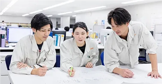 生産ラインの現場で打ち合わせをする三洋機工の社員